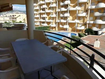 a table and chairs on a balcony with a swimming pool at Les Motes Solo Familias Serviplaya!!! in Playa de Xeraco