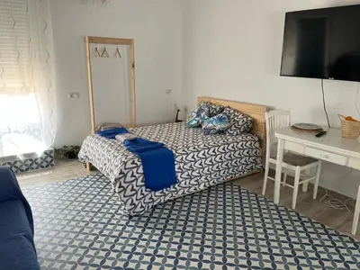 a bedroom with a bed and a desk and a television at Alzira bonita Ático E Plaza Mayor con gran terraza in Alzira