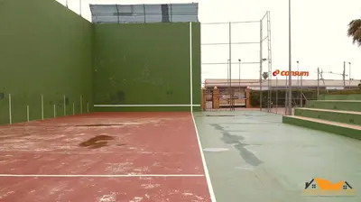 an empty tennis court with a green wall and stairs at Pobla-Mar in Valencia