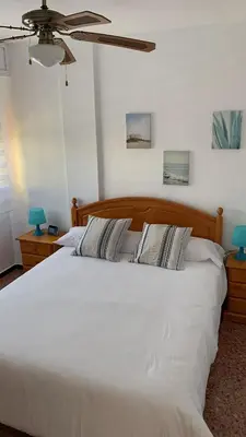 a large white bed in a bedroom with a ceiling fan at Pobla-Mar in Valencia