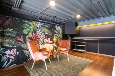 two chairs and a table in a room with a mural at Encantador Loft a un Paso del Río Turia in Valencia