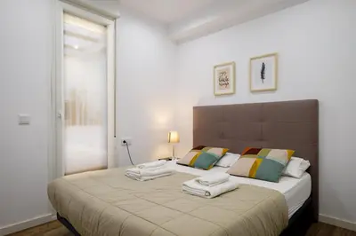 a bedroom with a large bed with towels on it at Apt with Fluffy Beds & Private Patio in Valencia