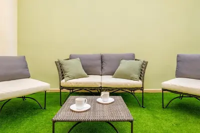 a room with two chairs and a couch and a table at Apt with Fluffy Beds & Private Patio in Valencia