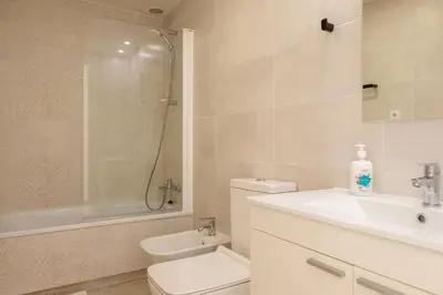 a bathroom with a toilet and a sink and a shower at Apt with Fluffy Beds & Private Patio in Valencia