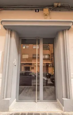 a reflection of a car in the window of a building at Apt with Fluffy Beds & Private Patio in Valencia