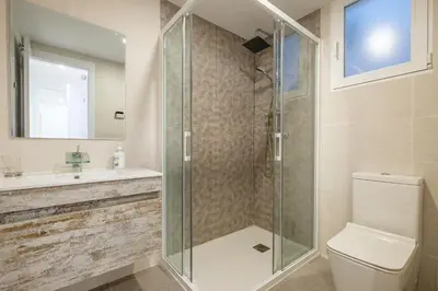 a bathroom with a shower and a toilet and a sink at Apt with Fluffy Beds & Private Patio in Valencia