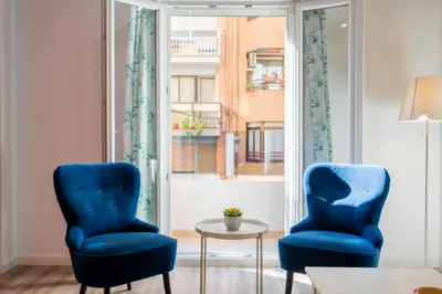 two blue chairs and a table in a room with a window at Spacious & Clean Apartment in Quiet Area in Valencia