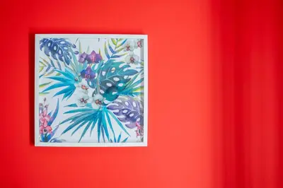 a picture of a painting of flowers on a red wall at Spacious & Clean Apartment in Quiet Area in Valencia