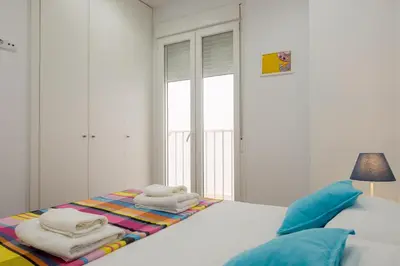a white bedroom with a bed with towels on it at Spacious & Clean Apartment in Quiet Area in Valencia