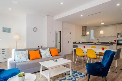 a living room and kitchen with a couch and chairs at Spacious & Clean Apartment in Quiet Area in Valencia