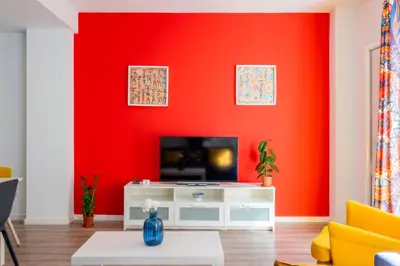 a living room with a red wall at Spacious Clean & Colorful Apt Quiet Zone in Valencia
