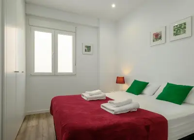 a bedroom with a large white bed with towels on it at Spacious Clean & Colorful Apt Quiet Zone in Valencia