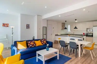 a living room with a blue couch and a table at Spacious Clean & Colorful Apt Quiet Zone in Valencia