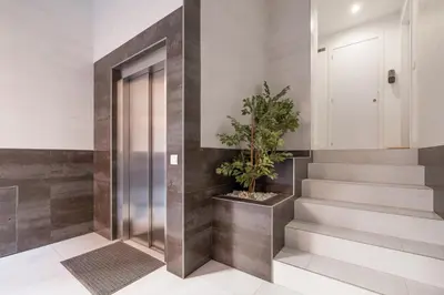a hallway with stairs and a door with a potted plant at Spacious Clean & Colorful Apt Quiet Zone in Valencia