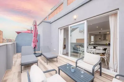 a balcony with chairs and an umbrella and a table at Modern Penthouse with Private Terrace in Valencia