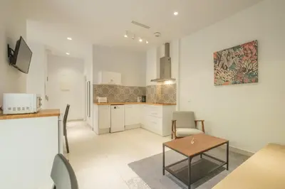 a living room with a table and a kitchen at Chic & Comfortable Apartment, Private Terrace in Valencia