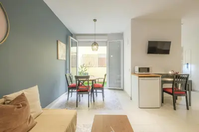 a living room with a table and chairs and a kitchen at Chic & Comfortable Apartment, Private Terrace in Valencia