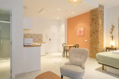 a bedroom with a bed and a chair and a table at Gorgeous Apartment close to City Centre in Valencia