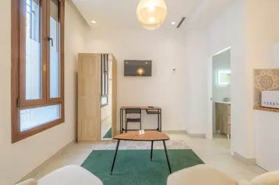 a room with a table and a tv on a wall at Gorgeous Apartment close to City Centre in Valencia