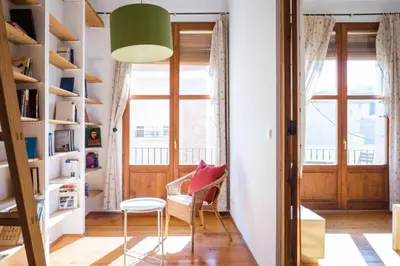 a living room with a green lamp and a chair at Old Town Plaza Negrito by Nomad Host in Valencia