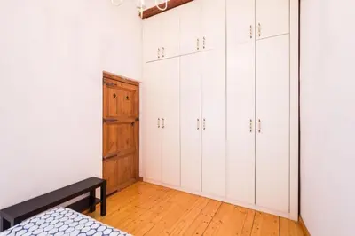 a bedroom with white cabinets and a wooden floor at Old Town Plaza Negrito by Nomad Host in Valencia
