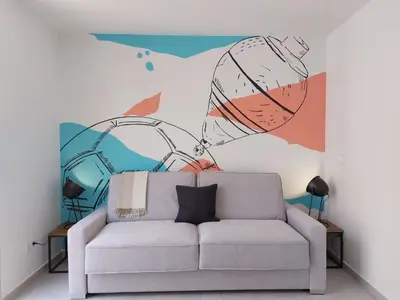 a living room with a couch in front of a mural at VLC HOST - Cuber in Valencia