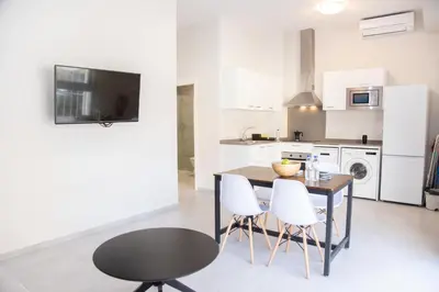 a kitchen with a wooden table and white chairs at VLC HOST - Cuber in Valencia