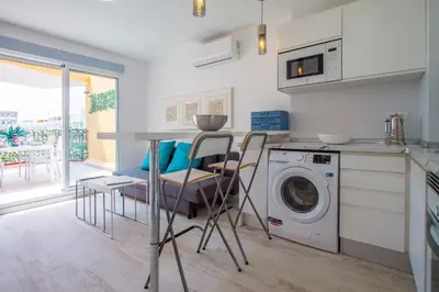 a kitchen with a table and a washing machine at PRIMERISIMA LINEA DE PLAYA - CULLERA BAHIA DE LOS NARANJOS I in Cullera