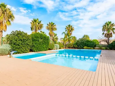 a swimming pool in a yard with palm trees at Apartment Porte Venere by Interhome in Moncófar