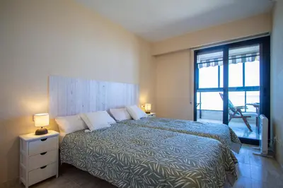 a bedroom with a large bed with a large window at ESPACIO 16 - Primera LINEA PLAYA in Cullera