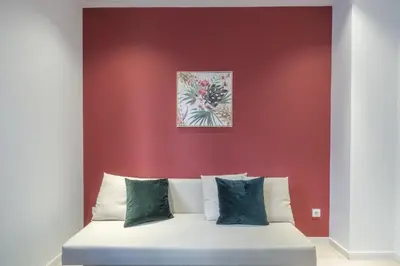 a bed in a room with a red wall at Modern Apartment close to City Centre in Valencia