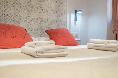 a bed with towels and red pillows on it at Modern Apartment close to City Centre in Valencia