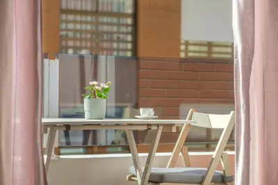 a table with a vase of flowers on a balcony at Modern, Stylish Apartment in Valencia
