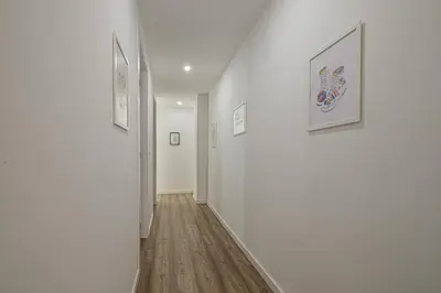 a hallway with white walls and paintings on the walls at Modern, Stylish Apartment in Valencia