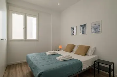 a white bedroom with a bed with towels on it at Modern, Stylish Apartment in Valencia