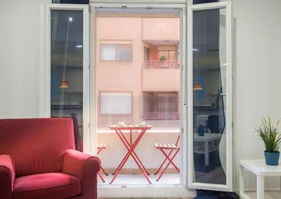 a living room with a red chair and a window at Apartment With Super Comfortable Beds in Valencia