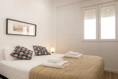 a white bedroom with a bed with towels on it at Clean & Very Comfortable Apartment in Valencia