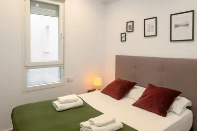 a bedroom with a large bed with red and white pillows at Clean & Very Comfortable Apartment in Valencia