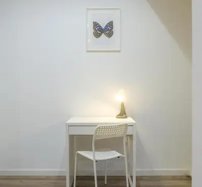 a desk with a chair and a butterfly picture on the wall at Bright, Brand new & Very Comfortable Apartment in Valencia
