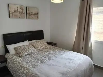a bedroom with two twin beds and a window at Apartamento Casa Quiles in Losa del Obispo
