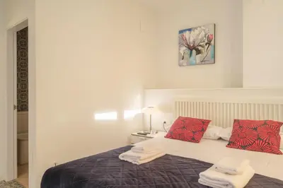 a bedroom with a bed with red and white pillows at Gorgeous Apt with a Large Private Terrace in Valencia