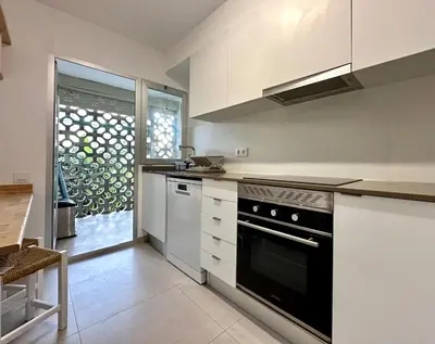 a kitchen with white cabinets and a black oven at Large Apartment with Sea Views in Sueca