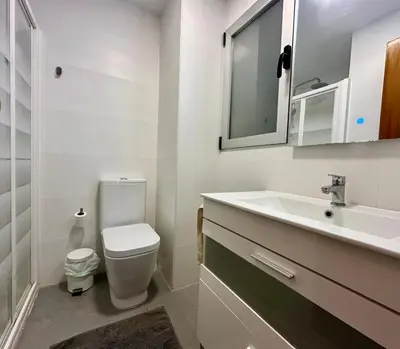 a white bathroom with a sink and a toilet at Large Apartment with Sea Views in Sueca