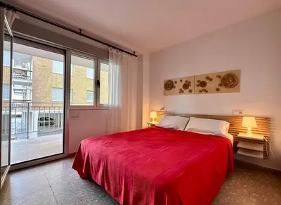 a bedroom with a red bed and a large window at Large Apartment with Sea Views in Sueca