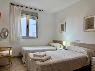 a white room with two beds and a window at Large Apartment with Sea Views in Sueca