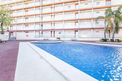 a swimming pool in front of a building at Balcón del Mar in Canet de Berenguer