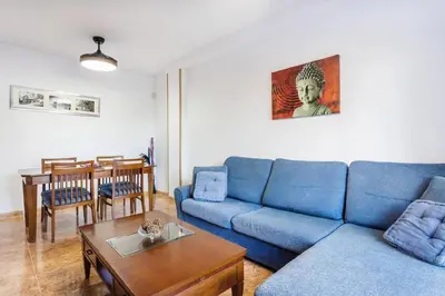 a living room with a blue couch and a table at Balcón del Mar in Canet de Berenguer