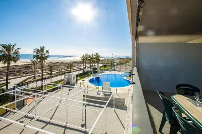 a view of a pool and the beach from a building at ESPACIO 2 Primera LINEA DE PLAYA in Cullera