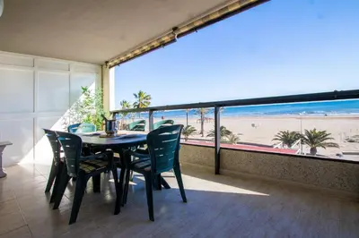 a dining room with a table and chairs and a view of the beach at ESPACIO 2 Primera LINEA DE PLAYA in Cullera