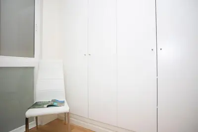 a row of white cabinets in a room with a chair at SingularStays Comedias IV in Valencia